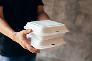 person holding foam lunch container