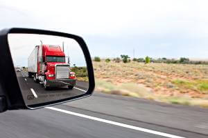 commercial truck pictured in sideview mirror
