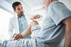 doctor examining patient's knee