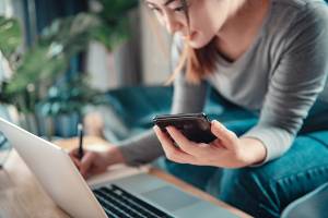 woman using calculator by laptop