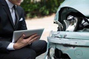 insurance adjuster reviewing damage to car