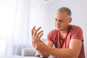 older man holding injured wrist