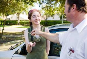 father handing car keys to daughter