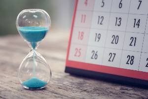 hourglass by calendar on table