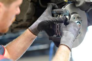 auto mechanic assembling brakes