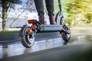 racing down street on e-scooter