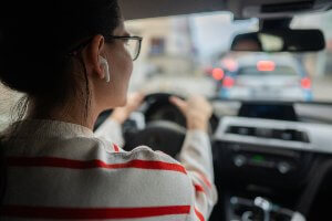 woman using airpods while driving