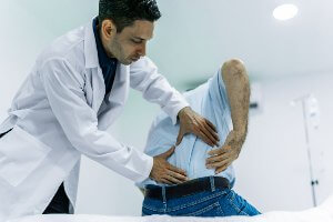 doctor examining patient with back pain