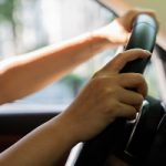 Current image: Someone's hands on a steering wheel