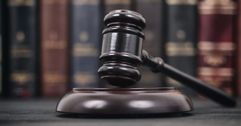 Current image: gavel on table by bookshelf