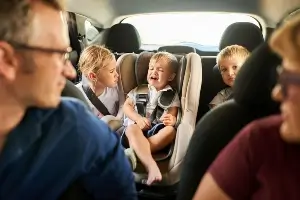 parents in car with crying children