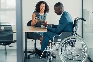 Woman reviews information with young man in wheelchair
