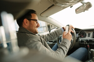 man looking at phone while driving
