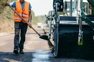 Road worker laying asphalt