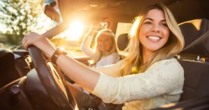 two blonde female teens; one driving