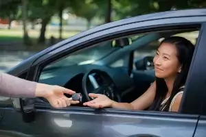 female teen driver being handed keys to car