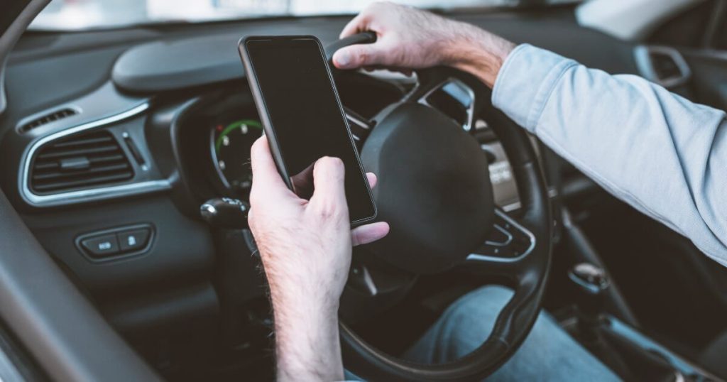 Current image: driver using phone while driving