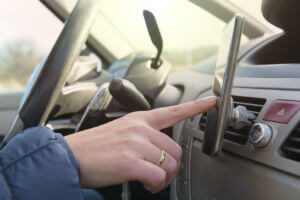 male-hand-touching-cellphone-in-car