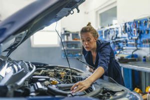 female mechanic working on car