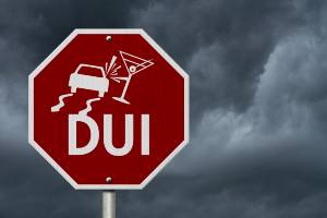 clouds behind road sign warning of DUI