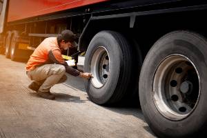 commercial truck driver studying tires