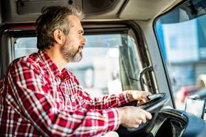 old truck driver in truck during the day