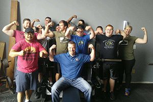 chuck slane flexing with weightlifting team