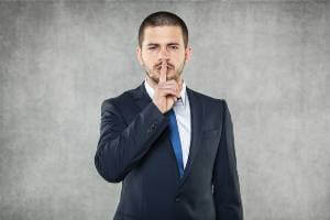 man putting finger over mouth