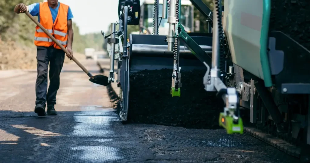 Current image: Road worker laying asphalt